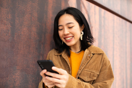 Portrait young woman smiling and holding cellphoneの写真素材