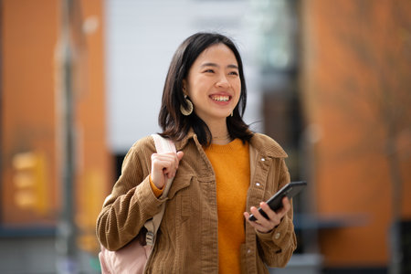 Portrait young asian woman with bag and holding mobile phoneの写真素材