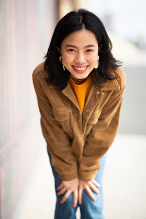 Portrait happy young woman standing with jacketの写真素材