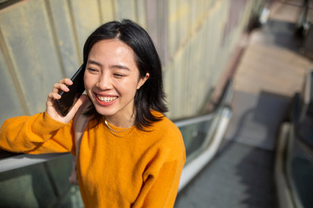 Portrait happy young woman talking with cellphoneの写真素材