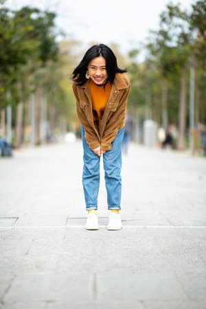 Full body portrait smiling young asian woman standingの写真素材
