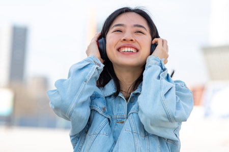 Portrait smiling young woman listening to music with headphonesの写真素材