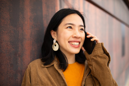 Portrait young woman smiling and talking with cellphoneの写真素材