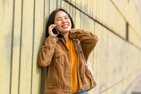 Portrait smiling young woman talking with phoneの写真素材