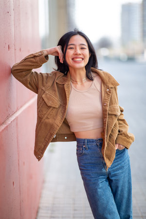 Portrait smiling young woman posing by wallの写真素材