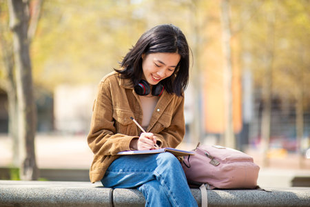 Portrait young woman sitting with pen and bookの写真素材