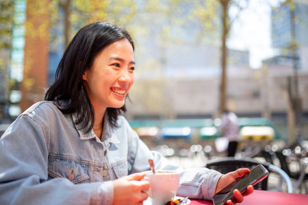 Portrait young woman sitting at cafe with mobile phone and drinkの写真素材