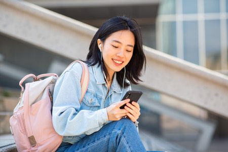 Portrait young asian woman sitting with cellphoneの写真素材