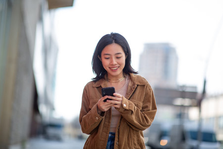 Portrait young woman using mobile phone in cityの写真素材