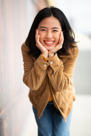 Portrait happy young woman with hands to chin poseの写真素材