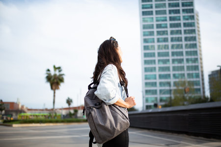 Side view portrait of woman with bag walking outside in cityの写真素材