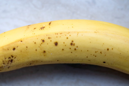Ripe banana with black dots.