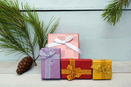 Christmas presents with pinecone and pine needles on blue and gray wooden backgroundの写真素材