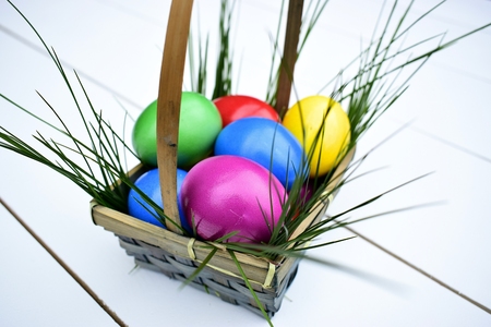 Colorful Easter eggs in a basket with fresh grass.