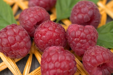 Ripe raspberries on straw plait.
