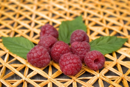 Ripe raspberries on straw plait.