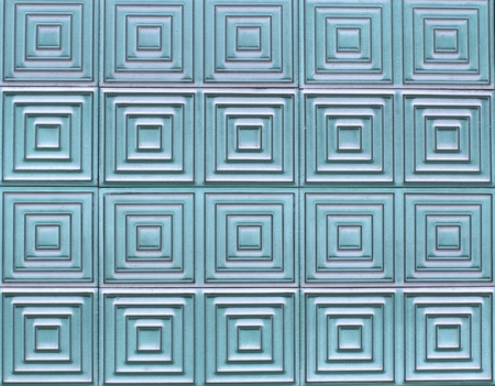 Old tiles on the wall with a unique pattern, turquoise color.