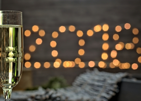 Moody new year concept glass with champagne on blurred new year background.の写真素材