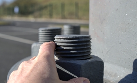 Technology, engineering, modernity and construction progress concept: A large metal screw securing a...