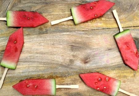 Sweet fresh dessert, watermelon and fruity concept: watermelon with sticks on a wooden board.の写真素材