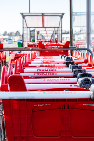 Roncq, FRANCE-February 25,2018: Close-up shopping trolleys Auchan hypermarket.Auchan is a French international supermarket chainのeditorial素材