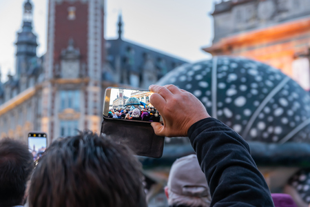 Lille, FRANCE-May 04,2019: Man who makes videos with a mobile phoneのeditorial素材