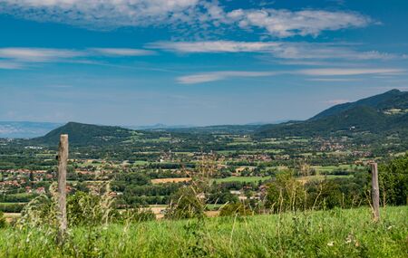 City landscape in the mountains, hills, fields, forests, green meadows, lakes in the distance and blue sky with clouds, focus area in the city. Haute-Savoie in France.の写真素材