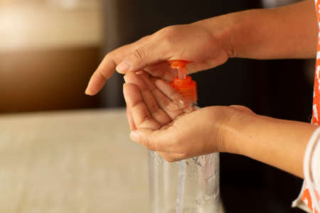 Woman doing Use of antibacterial gel with alcohol in home, hand cleaning, protection against corneal diseaseの写真素材