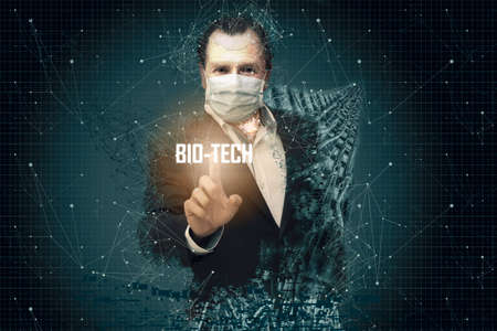 Middle-aged man in the shape of a robot and using mouth covers, touching a screen with a bio tech...