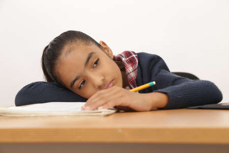 brunette girl does homework and classes writing in notebook and yellow pencilの写真素材