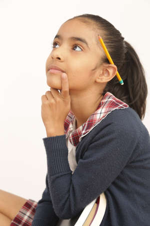 brunette latin student with school uniform in pose of thoughtful