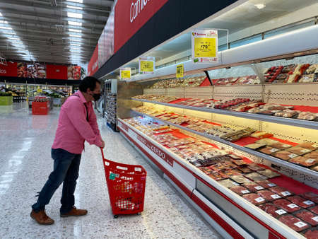 mature man wearing protection mask due to coronavirus, shopping at the superのeditorial素材