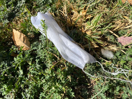 Infected protection mask, lying on the ground. environmental pollutionの写真素材