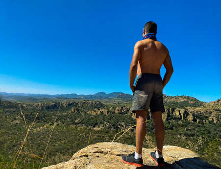 young man triumphing in the mountains. Conquering his fears. Confronting fearの写真素材