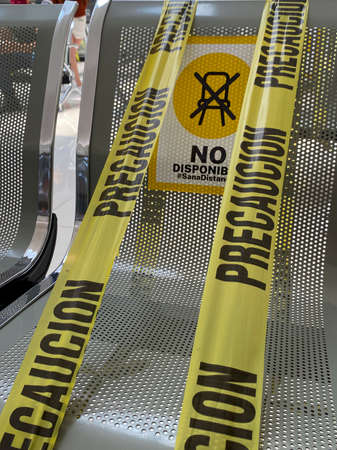 Mexico, 02 February 2021, public chairs with caution tape, due to pandemic. Tape with legend caution do not use this seatの写真素材