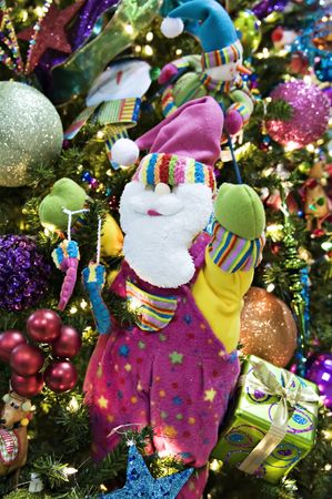 A waving santa ornament holding on to a treeの写真素材