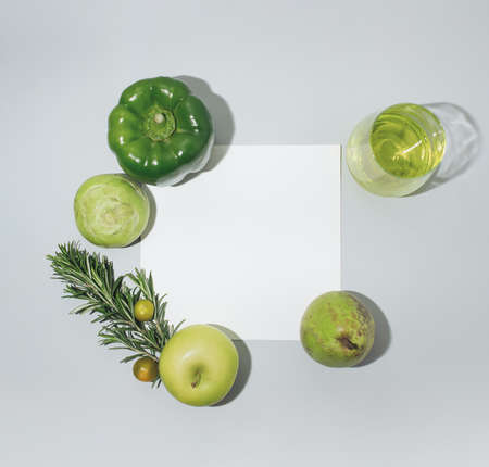 Fresh green fruits and vegetables on flat lay white paper and grey background. Minimal flat composition.の写真素材