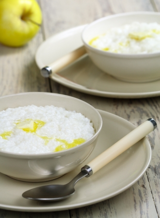 Rice porridge with butter on a wooden tableの写真素材