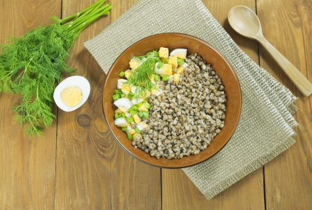 Buckwheat in a brown bowl on wooden tableの写真素材