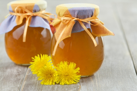 Jam  of dandelions in the jars on a wooden tableの写真素材