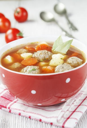 Tomato soup with meatballs in a bowl on the wooden tableの写真素材