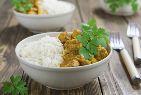 Chicken curry with rice in a bowl on the tableの写真素材