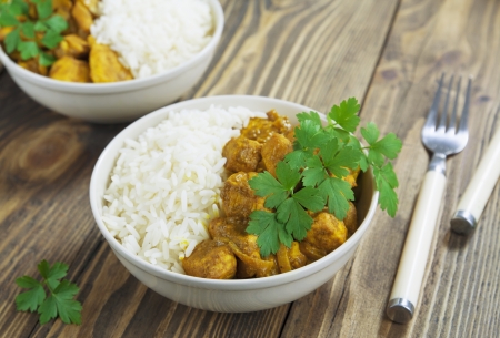 Chicken curry with rice in a bowl on the tableの写真素材
