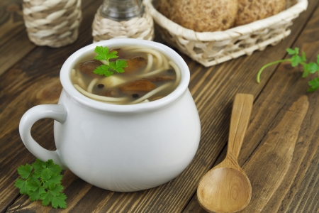 Mushroom soup with pasta in the pot on the wooden tableの写真素材