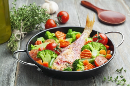 Fried fish with vegetables in the  panの写真素材