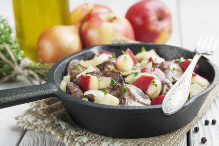 Chicken liver stewed with apples and onion in the frying pan の写真素材