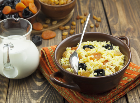 Millet porridge with dried apricots and prunes in a bowlの写真素材