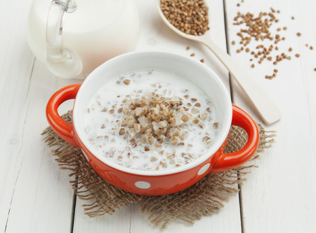 Buckwheat porridge with milk in the bowl on the tableの写真素材