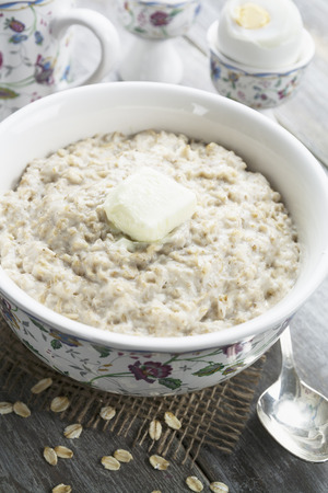 Porridge with butter and eggs on the wooden tableの写真素材