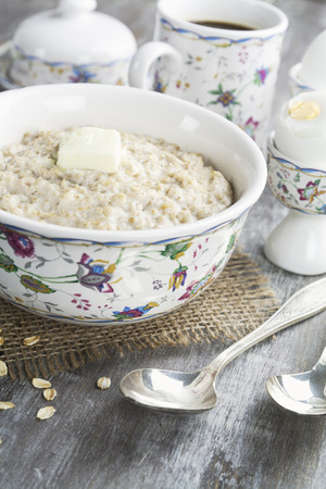 Porridge with butter and eggs on the wooden tableの写真素材